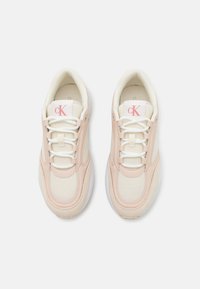 Calvin Klein sportcipők rózsaszín és krémszín kombinációban. Vászonból és szintetikus anyagokból készült, fűzős dizájnnal és fehér gumitalppal rendelkezik.