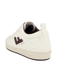 White low-top sneaker with dark brown interior, brown "FL" logo on side, and embossed "FLAMINGO'S LIFE" on sole, viewed from back angle.