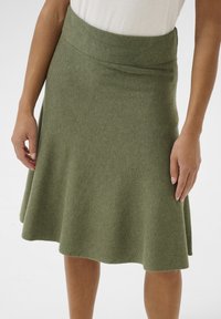 Jupe A-line longueur genoux en olive, fabriquée en tissu doux avec une surface lisse et une taille large pour plus de confort.
