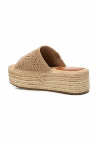 Sándalo tipo espadrille de color beige claro con parte superior de ante perforado, plataforma envuelta en yute y suela de goma plana. Textura suave y forma redondeada.