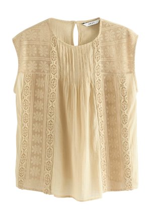 Ljusbeige blus med korta ärmar, med broderade paneler och nyckelhål baktill. Mjuk tyg med veck och detaljerade spetsaccenter.