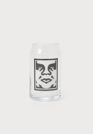 Transparent Glasbecher mit einer schwarz-weißen Grafik eines Gesichts innerhalb eines rechteckigen Rahmens, glatte Textur und leicht gebogene Form.