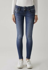 Smala blå jeans i denim med en blekt tvätt. Har två framfickor och en dubbelknäppning på ett högt midjeband.