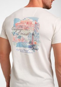 Helle beige Baumwoll-T-Shirt mit einem bunten Druckdesign auf der Rückseite, das einen Leuchtturm und Palmen zeigt, mit dem Text "Cap Ferret".