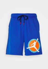 Pantaloni corti in rete blu con vita elasticizzata e cordino. Presenta un grande logo circolare di Air Jordan sulla sinistra. Dettagli in arancione e bianco.