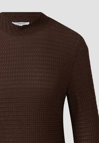 Ciemnobrązowy sweter o fakturowanym splocie, z okrągłym dekoltem, długimi rękawami i subtelnym wzorem waflowym.