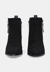 Botines de ante negro con textura suave, puntera cuadrada y cremalleras laterales, que presentan una suela baja y plana y detalles de hardware mínimos.