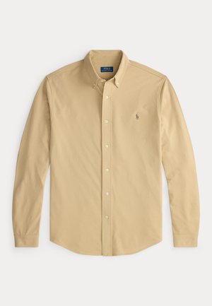 Beżowa koszula z długim rękawem na guziki, z kołnierzykiem zapinanym na guziki i małym haftowanym logo Polo Ralph Lauren na lewej piersi.