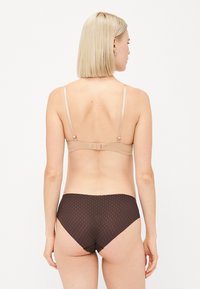 Beige bralette met verstelbare bandjes en haaksluiting, gecombineerd met donkere bruine hooggesneden slip met een gestructureerd patroon.