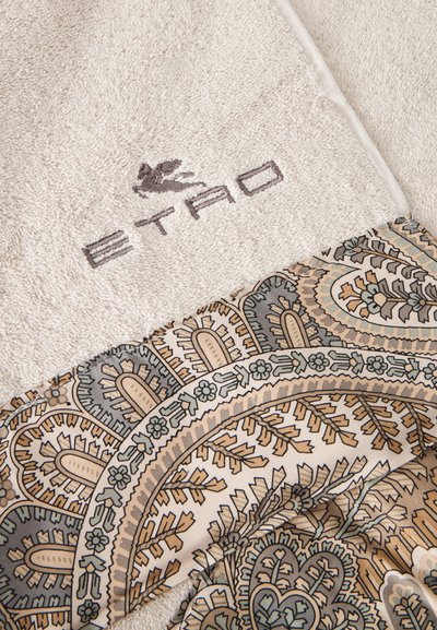 Serviette beige douce avec broderie du logo ETRO et bord en tissu plié présentant un motif paisley détaillé dans des tons sourds.