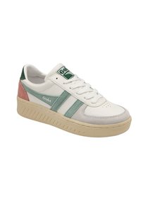Sneaker blanche avec des accents verts et roses, matériaux en cuir et en suède, semelle intermédiaire texturée et marquage prominent sur la languette.