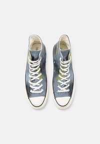 Sneakers alte in tessuto blu con dettagli verdi, lacci bianchi e punta in gomma bianca. Texture liscia, suola a contrasto e soletta con marchio.