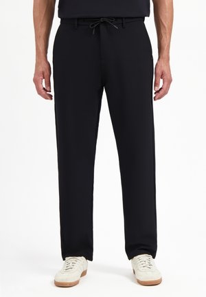 Zwarte, drawstring broek met een reguliere pasvorm. Gemaakt van een gladde, gestructureerde stof, met zijzakken en een subtiele logodetail.