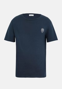 Μπλε σκούρο t-shirt με κοντά μανίκια, στρογγυλή λαιμόκοψη και μικρό λευκό σχέδιο με κεφάλι λιονταριού στην αριστερή πλευρά του στήθους.