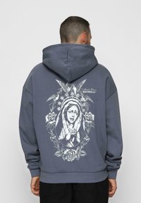Felpa grigia con cappuccio, caratterizzata da una grande grafica bianca di una figura circondata da rose e uccelli sul retro, con cappuccio regolabile e polsini a costine.