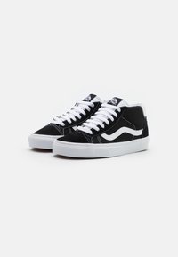Zwarte suède hoge sneakers met witte accenten, witte veters en rubberen zolen. Kenmerken zijn een logo patch op de tong en een zijkantstreep ontwerp.