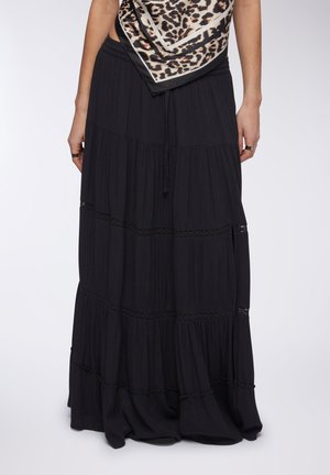 Gonna maxi nera con design a volant a più livelli, caratterizzata da dettagli in pizzo e una vita elasticizzata per una vestibilità regolabile. Tessuto leggero.