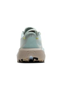 Zapatilla deportiva de color azul claro con parte superior de malla texturizada, un collar acolchado y una media suela gruesa beige con patrones negros en la suela.