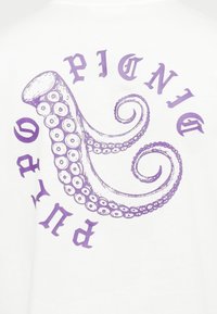 Valge T-särk, millel on lillakate keerlevate tentaklitega oktoobuse illustratsioon ja selle ümber paiknev tekst, moodustades ümmarguse mustri.