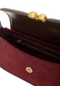 Vnitřek bordó kordurového kabelky s tmavohnědou koženou podšívkou, obsahující zipovou kapsu a zlatý klipsový kovový prvek.