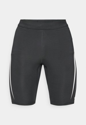 Shorts de sport noirs avec des bandes blanches sur les côtés, fabriqués en tissu extensible, dotés d'une taille haute et d'une coupe ajustée pour le confort.