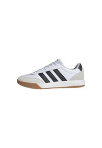 Zapatilla deportiva blanca con detalles en ante gris, tres franjas negras y suela de goma color caramelo. Cuenta con un diseño de cordones y un cuello acolchado.