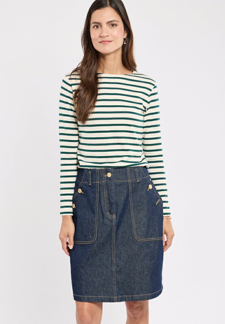 Haut à rayures à manches longues en vert et blanc, associé à une jupe en denim bleu foncé avec deux poches avant et des accents de boutons dorés.