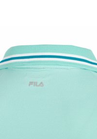 Polo shirt verde chiaro con colletto a coste caratterizzato da strisce bianche e teal, realizzato in materiale testurizzato. Logo FILA in un grigio delicato.