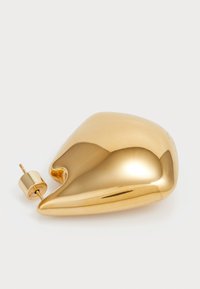 Gold-toned abstract-shaped earring with a smooth, shiny surface and a cylindrical post closure, featuring a pointed tip.