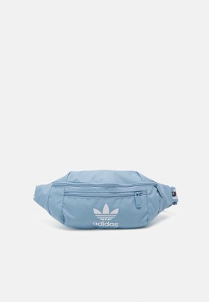Jasnoniebieska nerka Adidas z przednią kieszenią na suwak i białym logo trefoil na jednolitym tle.