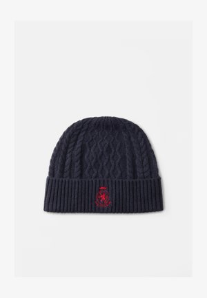 Marine gebreide beanie met kabelpatroon, geribbelde manchet en rood geborduurd logo aan de voorkant. Zachte textuur, geschikt voor koud weer.