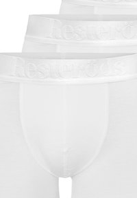 Valkoiset puuvillabokserit, joissa on sileä pinta, pehmeä elastinen vyötärönauha, jossa on kohokuvioitu "Resteröds" -logo, sekä istuva muotoilu.