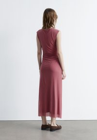 Staubrosafarbene, ärmellose Maxikleid mit tailliertem Oberteil und gerafftem Detail an der Taille, mit einem fließenden Saum und leichtem, weichem Stoff.