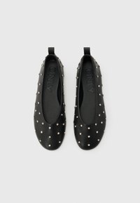 Μαύρα πλατφόρμες χωρίς κορδόνια με μικρές ασημένιες τρουκς που καλύπτουν ομοιόμορφα την επιφάνεια, στρογγυλεμένες μύτες και θηλιές στο πίσω μέρος, με τη μάρκα "ONLY" στο εσωτερικό.