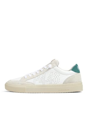 Sneaker bianca low-top con accenti in camoscio beige, dettaglio laterale traforato, lacci bianchi, suola beige e linguetta verde sul tallone con testo bianco.