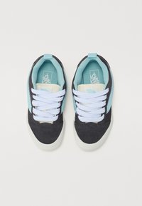 Sorte og teal teksturerte sneakers med hvite snørebånd, med en lys blå aksent på siden og en myk innerforing.