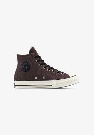 Dunkelbrauner High-Top-Converse-Sneaker mit strukturiertem Stoff, schwarzen Schnürsenkeln, weißer Gummisohle und schwarzem Logopatch am Knöchel.