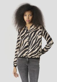 Bomberjack met zebraprint in beige en zwart, voorzien van een ritssluiting aan de voorkant, geribbelde zoom en manchetten, met een gladde, glanzende textuur.