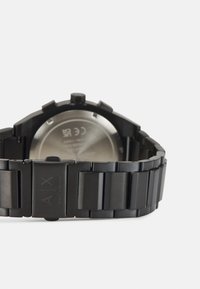 Orologio in acciaio inox nero con finitura opaca, caratterizzato da un bracciale massiccio e una cassa rotonda lucida. Il retro mostra i dettagli del produttore.