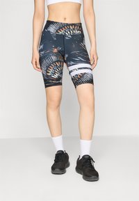 Fietsshorts van donkere stof met een kleurrijk veerpatroon, hoge taille ontwerp en witte horizontale strepen bij de bovenbenen.