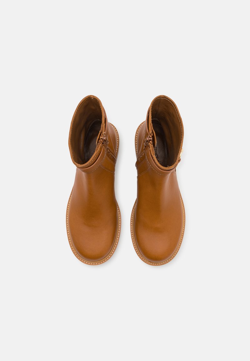 Bruine leren enkellaarzen met een gladde afwerking, zijrits en ronde neus. Gedetailleerde stiksels rond de zool zorgen voor contrast.