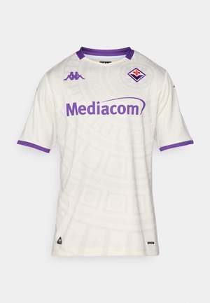 Bela nogometna majica s subtilnim vzorcem, vijoličasti detajli na ovratniku in rokavih, z logotipom "Mediacom" v vijoličasti barvi.