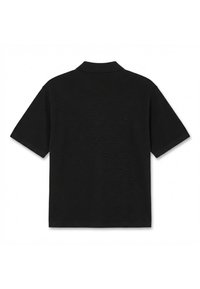 Polo noir à manches courtes avec tissu texturé et col classique, vu de dos sur un fond blanc.