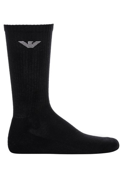 Calza nera lunga con texture a coste, punta e tallone rinforzati. Presenta un piccolo emblema sulla parte superiore del polsino. Realizzata in materiale misto cotone.