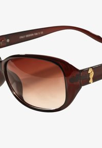 Brązowe okulary przeciwsłoneczne w stylu tortoise z gradientowymi soczewkami, z złotym akcentem w kształcie konika morskiego na ramieniu, gładką teksturą i szerokim prostokątnym kształtem.