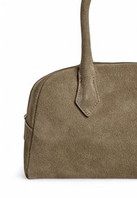 Sac à main en daim vert olive avec une texture lisse, une forme arrondie et des accents cousus. Il possède une seule poignée robuste pour le transport.