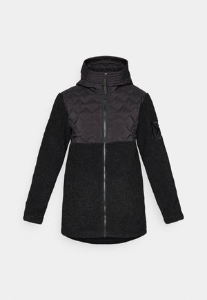 Svart hettegenser med kviltet brystpanel, glidelås foran, strukturert fleece-kropp og ermer, og en liten lomme på venstre arm.