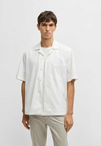 Witte korte mouwen overhemd met een knoopsluiting aan de voorkant, kraag en een enkele borstzak. Gemaakt van een gladde stof, geschikt voor casual kleding.