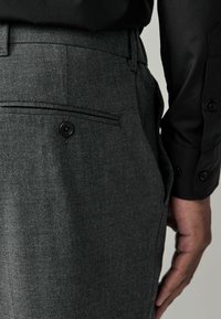 Sive tailoring hlače od teksturirane tkanine, s stražnjim džepom s crnim gumbom i ravnim prednjim dizajnom.