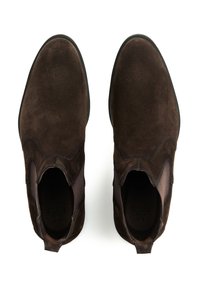 Brązowe zamszowe botki za kostkę z elastycznymi panelami po bokach i gładką gumową podeszwą. Cholewa charakteryzuje się subtelną fakturą i smukłym kształtem.